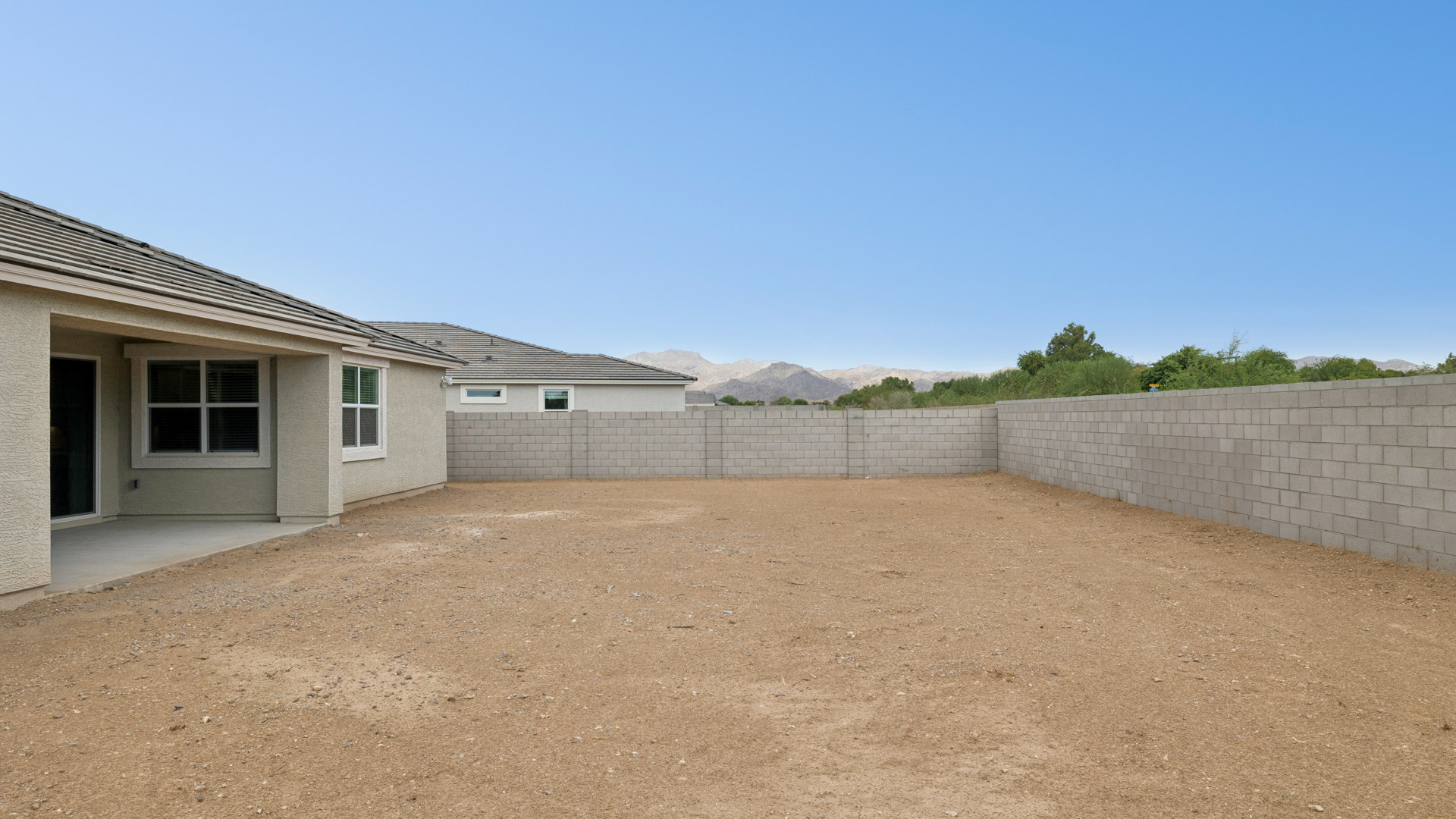 Outdoor covered patio with seating area overlooking a well-maintained lawn, perfect for relaxation.