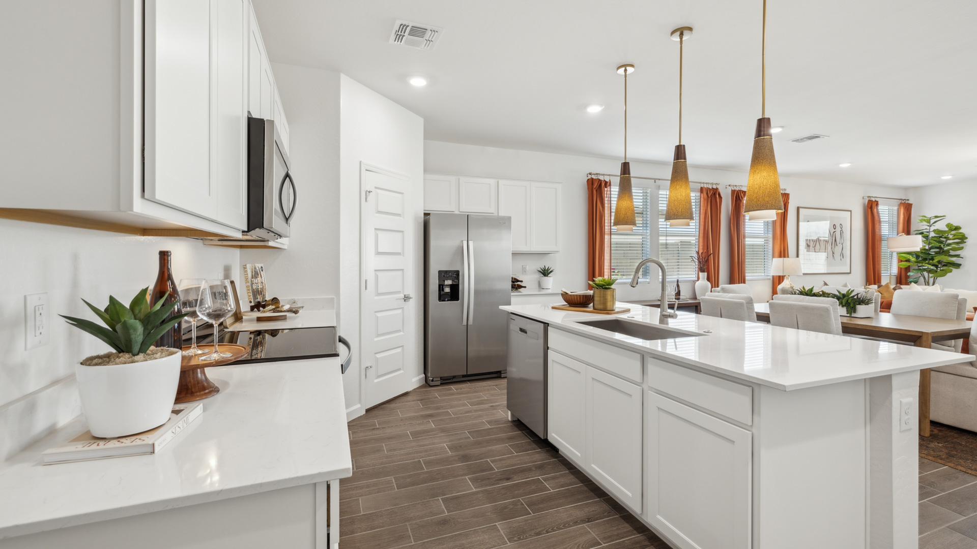 Bright and spacious kitchen with quartz countertops, stainless steel appliances, and an island with bar seating.