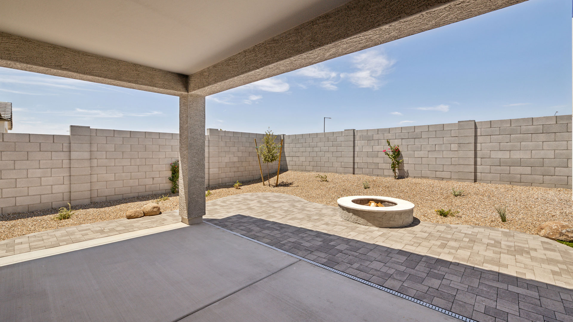 Outdoor covered patio with seating area overlooking a well-maintained lawn, perfect for relaxation.