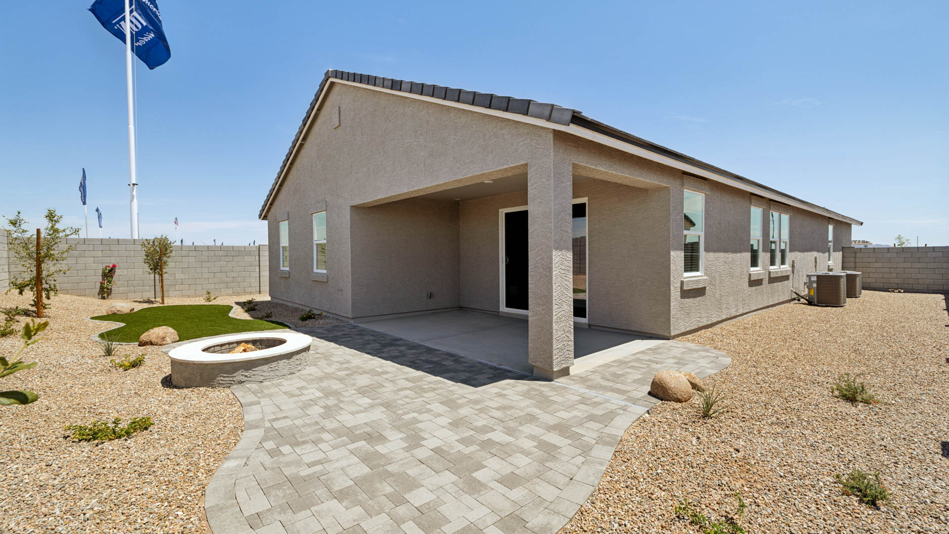 Outdoor covered patio with seating area overlooking a well-maintained lawn, perfect for relaxation.