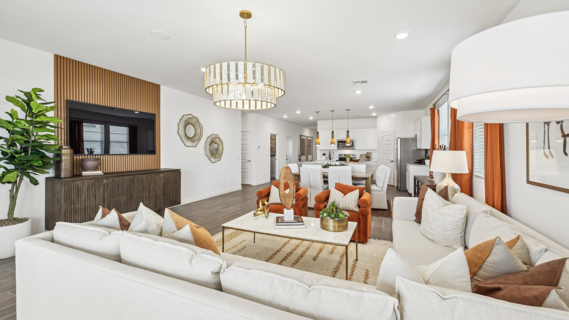 A well-organized living room that includes a kitchen and dining area, creating a warm and welcoming environment for gatherings.