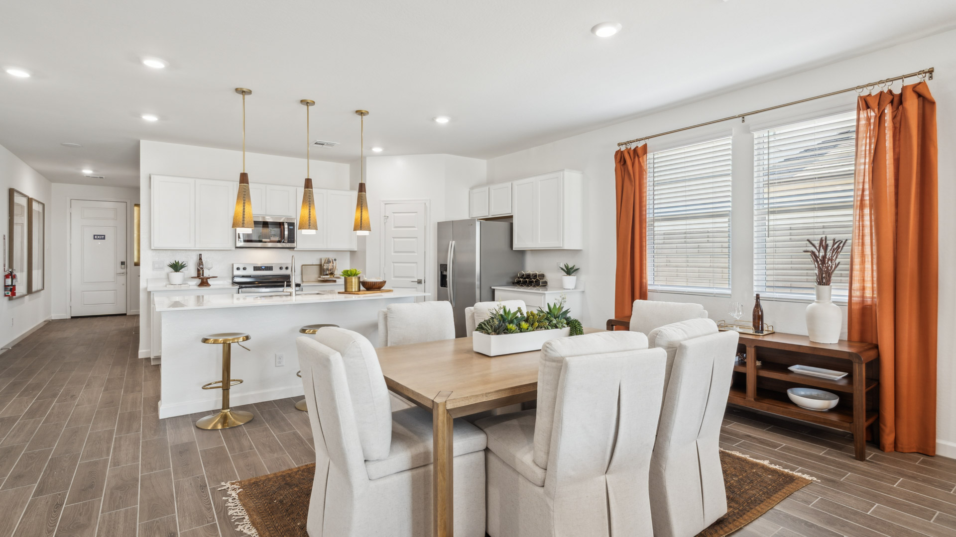 A well-organized living room that includes a kitchen and dining area, creating a warm and welcoming environment for gatherings.
