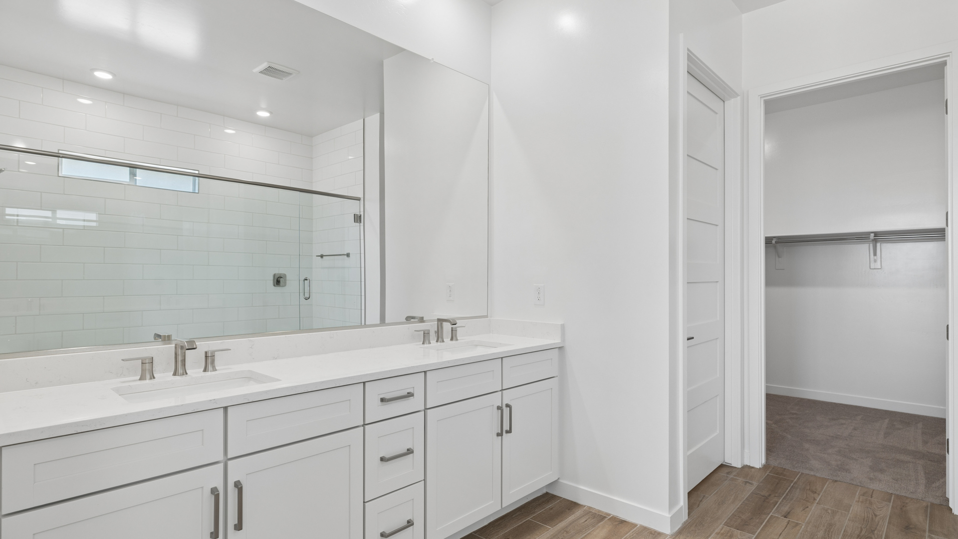 primary spa inspired bathroom with dual vanities and walk in shower