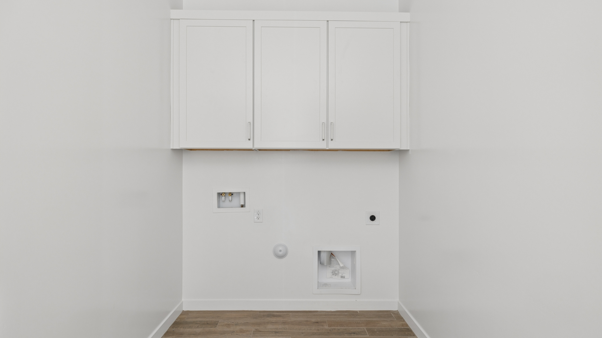 large laundry room with shelving and cabinets