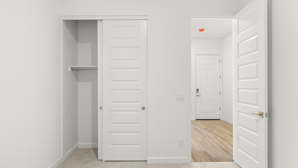 Comfortable guest bedroom featuring neutral-toned walls and a large closet.