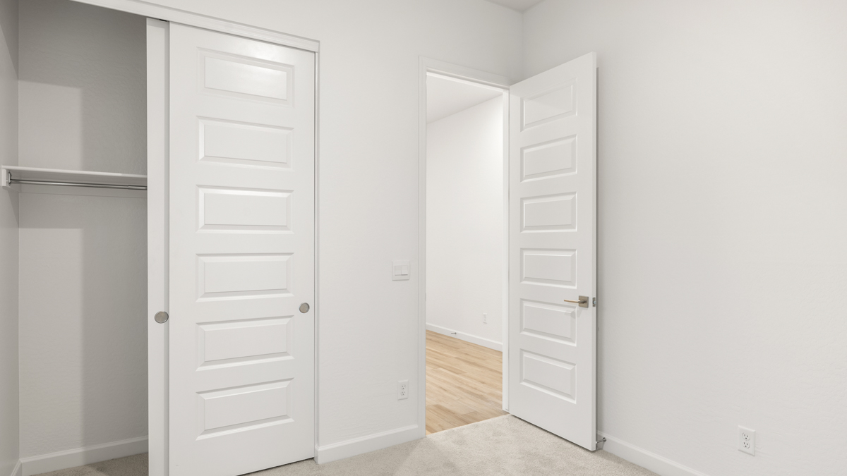 Comfortable guest bedroom featuring neutral-toned walls and a large closet.