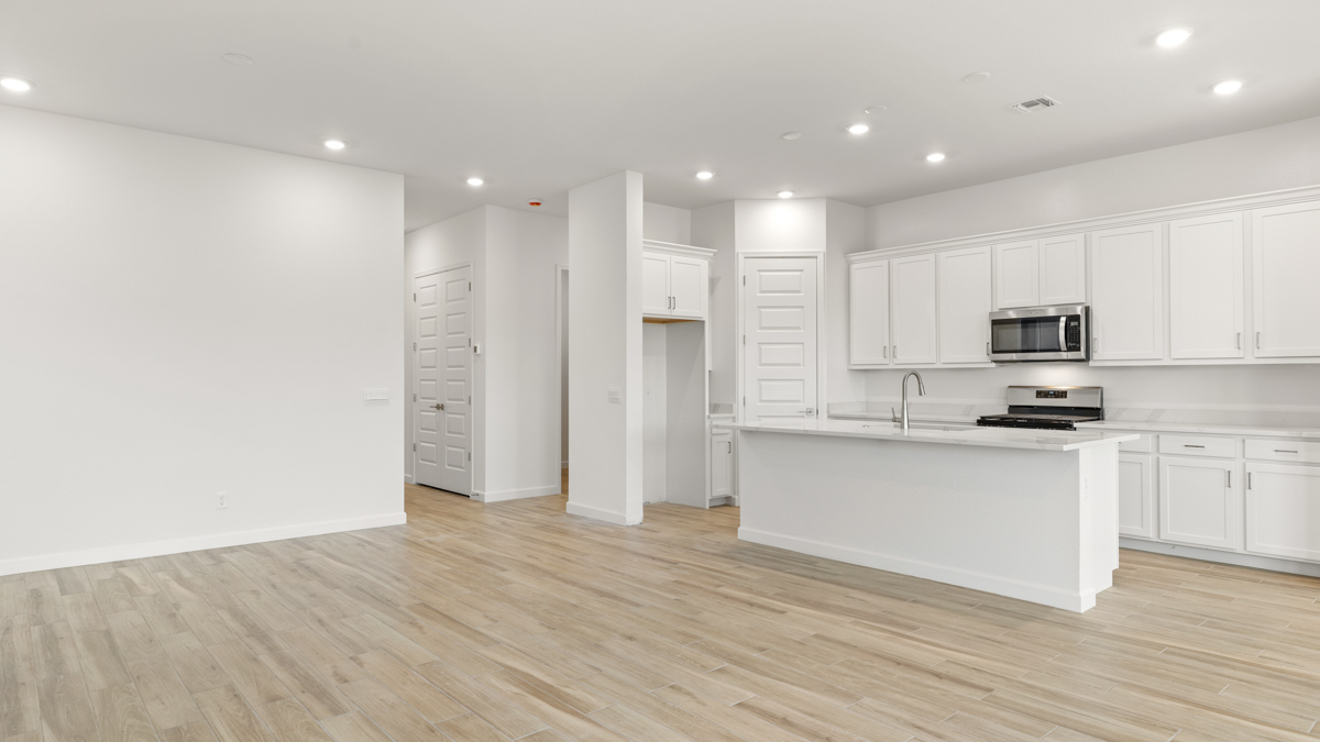Bright and spacious kitchen with quartz countertops, stainless steel appliances, and an island with bar seating.
