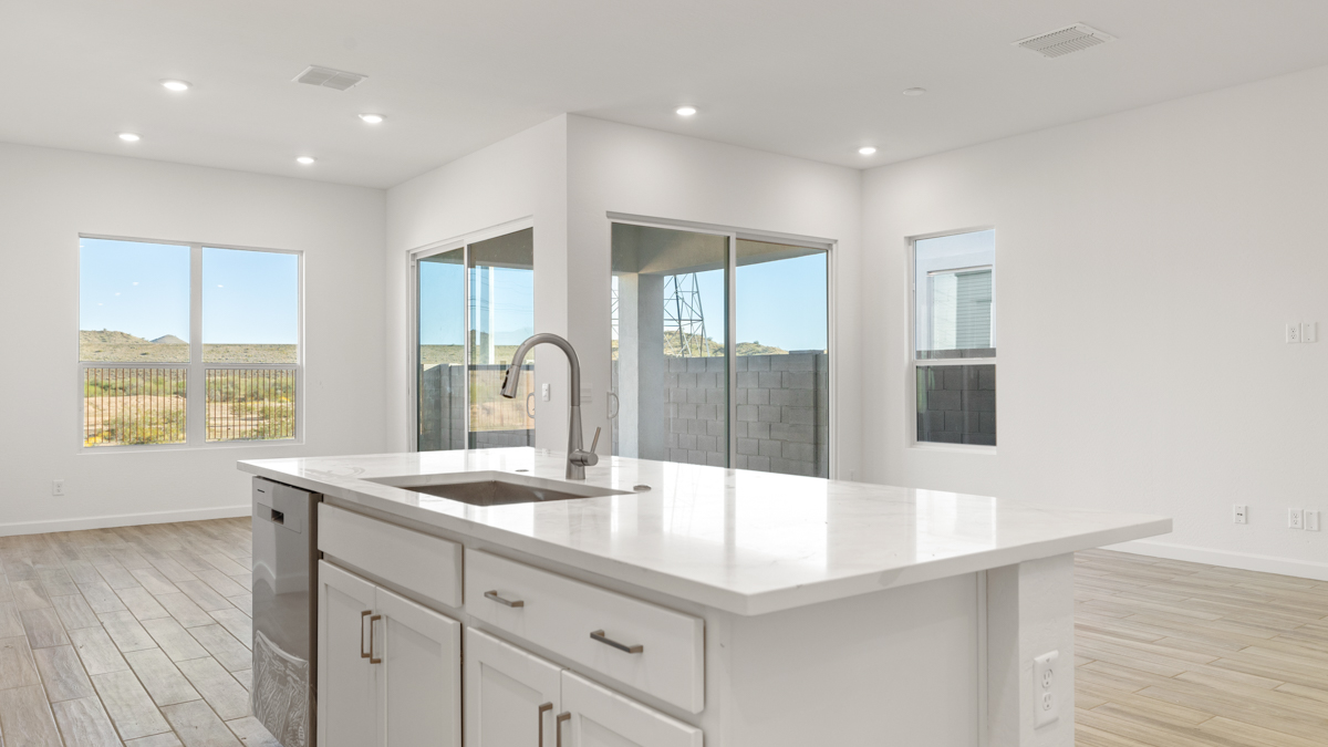 Bright and spacious kitchen with quartz countertops, stainless steel appliances, and an island with bar seating.