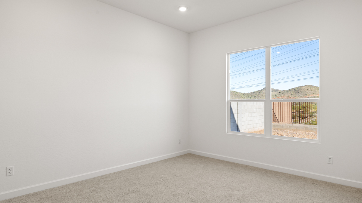 A spacious primary bedroom emphasizing open space and natural lighting.