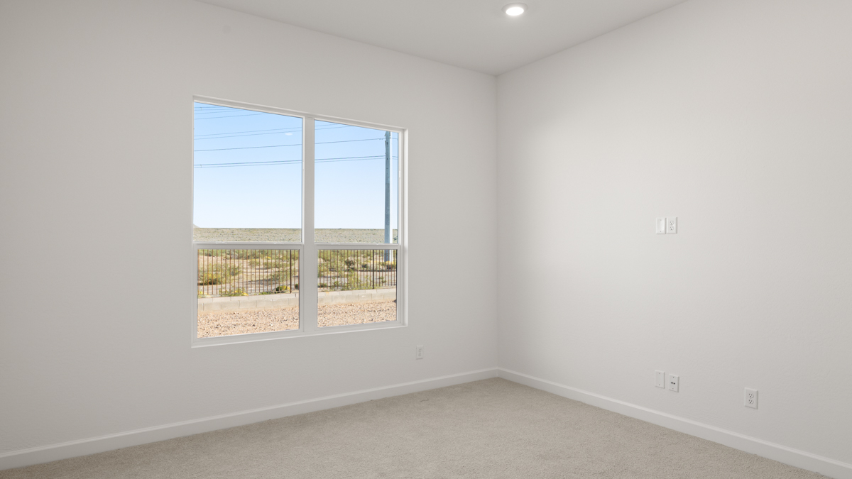 A spacious primary bedroom emphasizing open space and natural lighting.