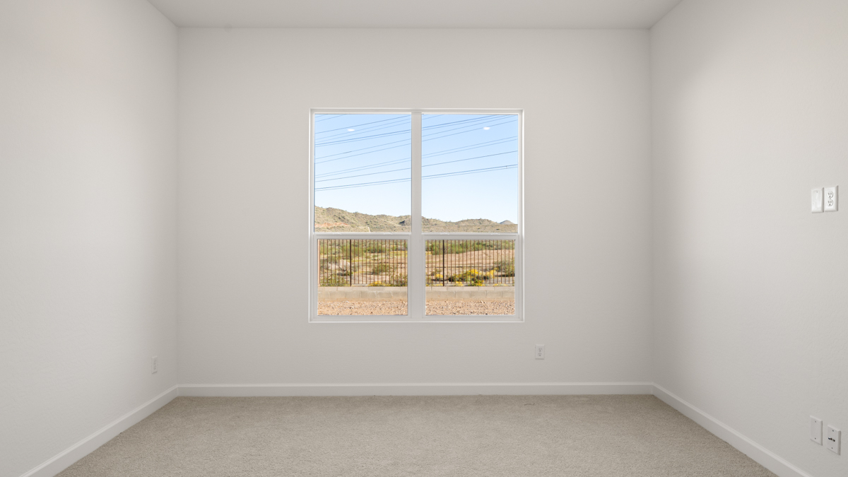 A spacious primary bedroom emphasizing open space and natural lighting.