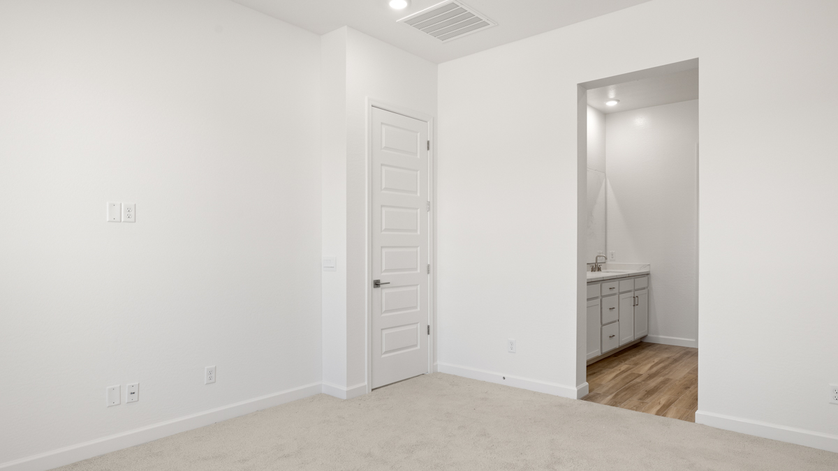 A spacious primary bedroom emphasizing open space and natural lighting.