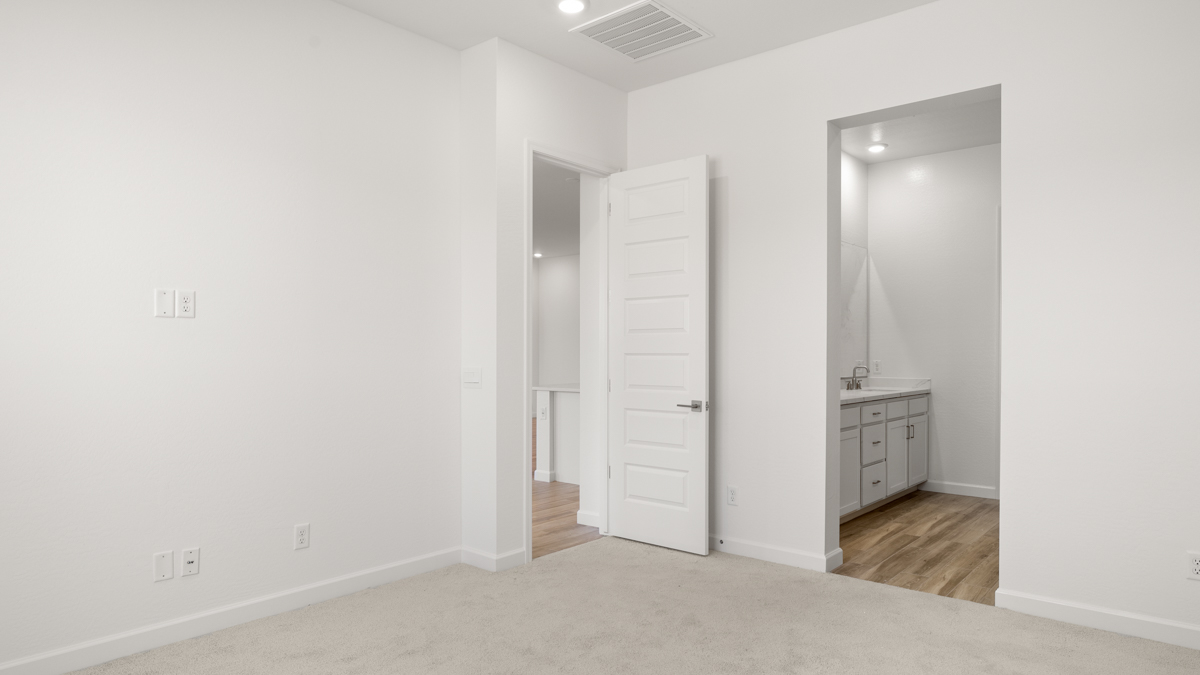 A spacious primary bedroom emphasizing open space and natural lighting.