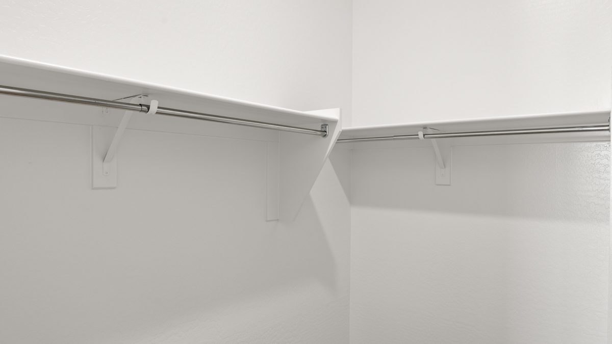 Modern primary bathroom with double vanities, quartz countertops with a walk-in shower and a walk-in closet.