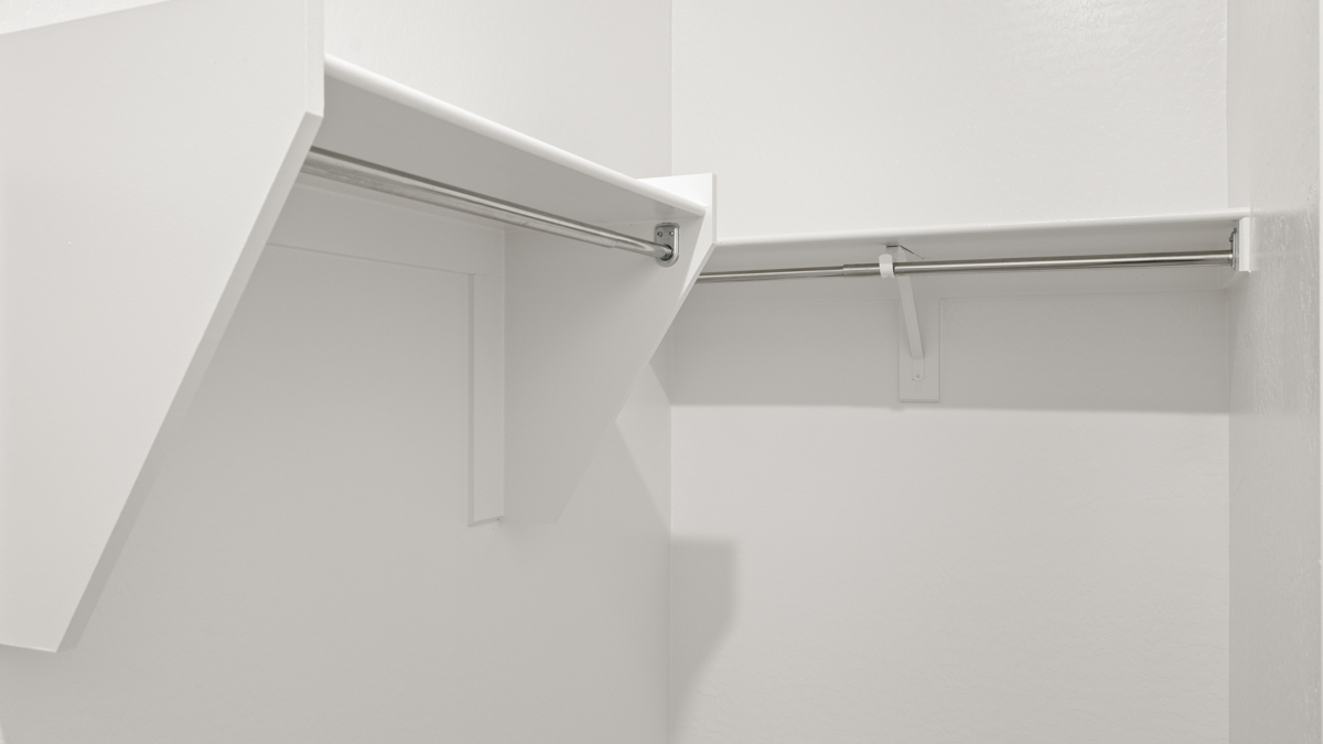 Modern primary bathroom with double vanities, quartz countertops with a walk-in shower and a walk-in closet.