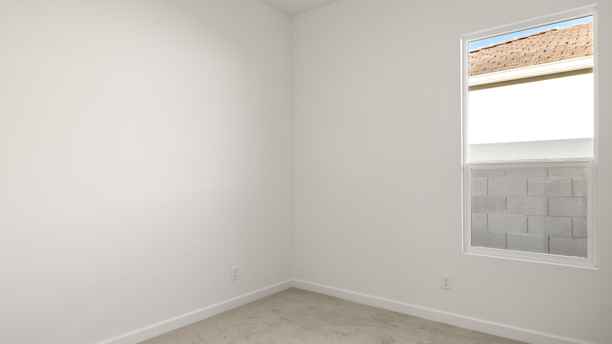 Comfortable guest bedroom featuring neutral-toned walls and a large closet.
