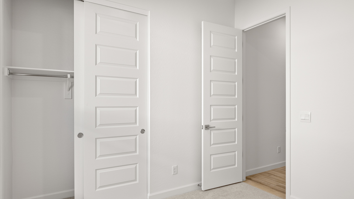 Comfortable guest bedroom featuring neutral-toned walls and a large closet.