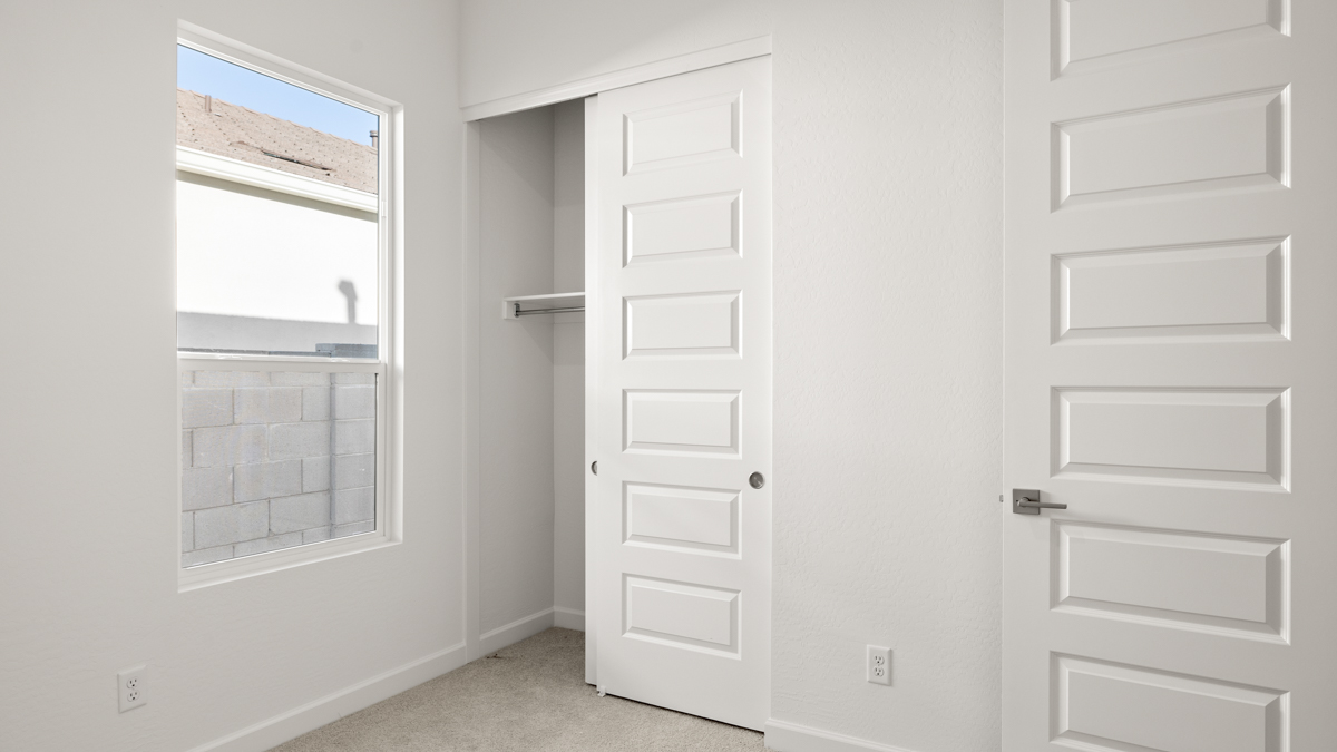 Comfortable guest bedroom featuring neutral-toned walls and a large closet.