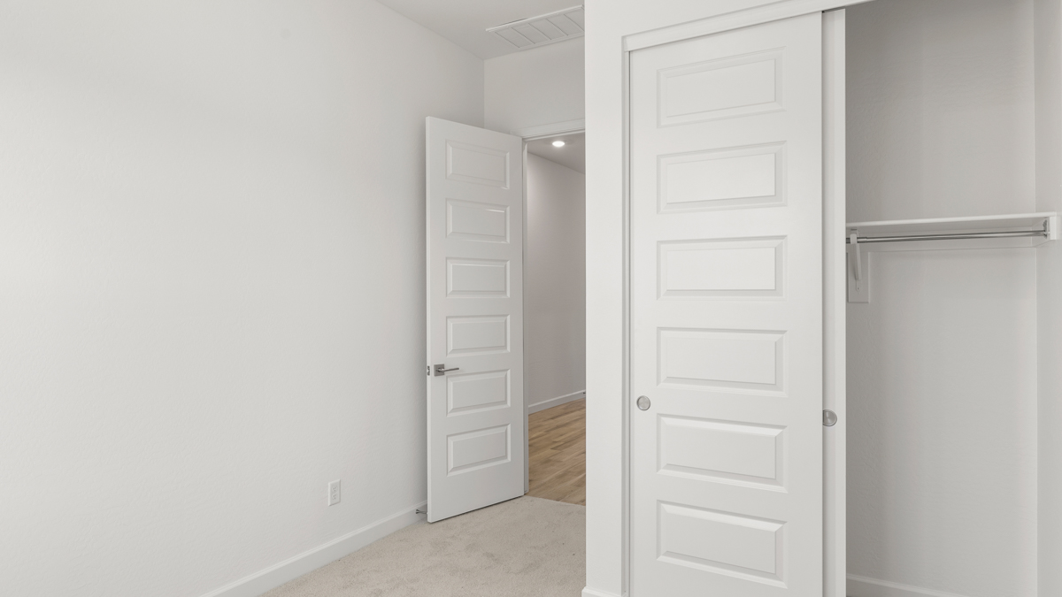 Comfortable guest bedroom featuring neutral-toned walls and a large closet.