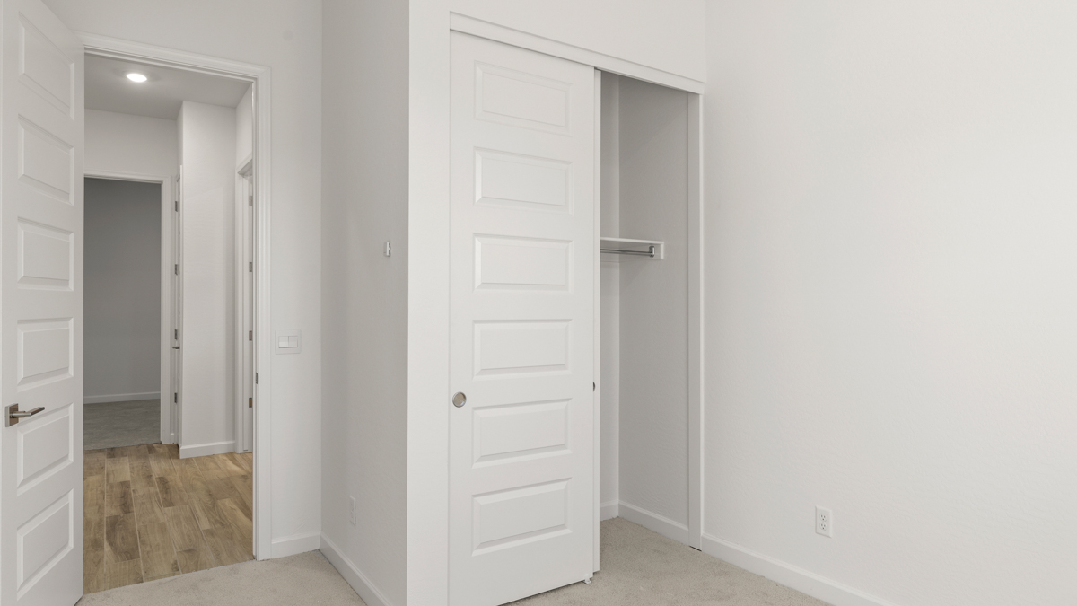 Comfortable guest bedroom featuring neutral-toned walls and a large closet.