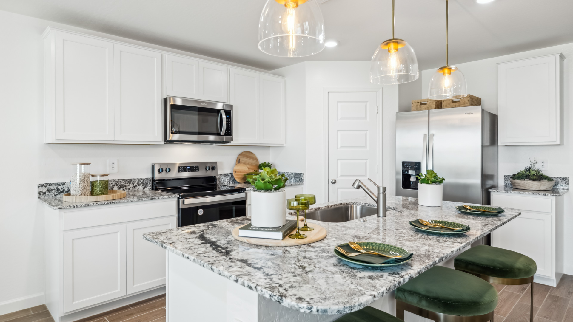 Bright and spacious kitchen with granite countertops, stainless steel appliances, and an island with bar seating.