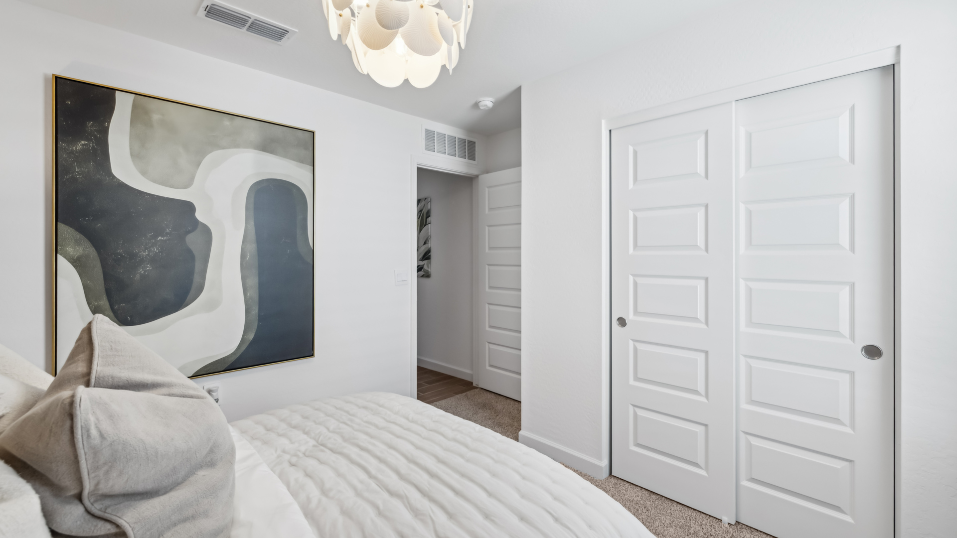 Comfortable guest bedroom featuring neutral-toned walls and a large closet.