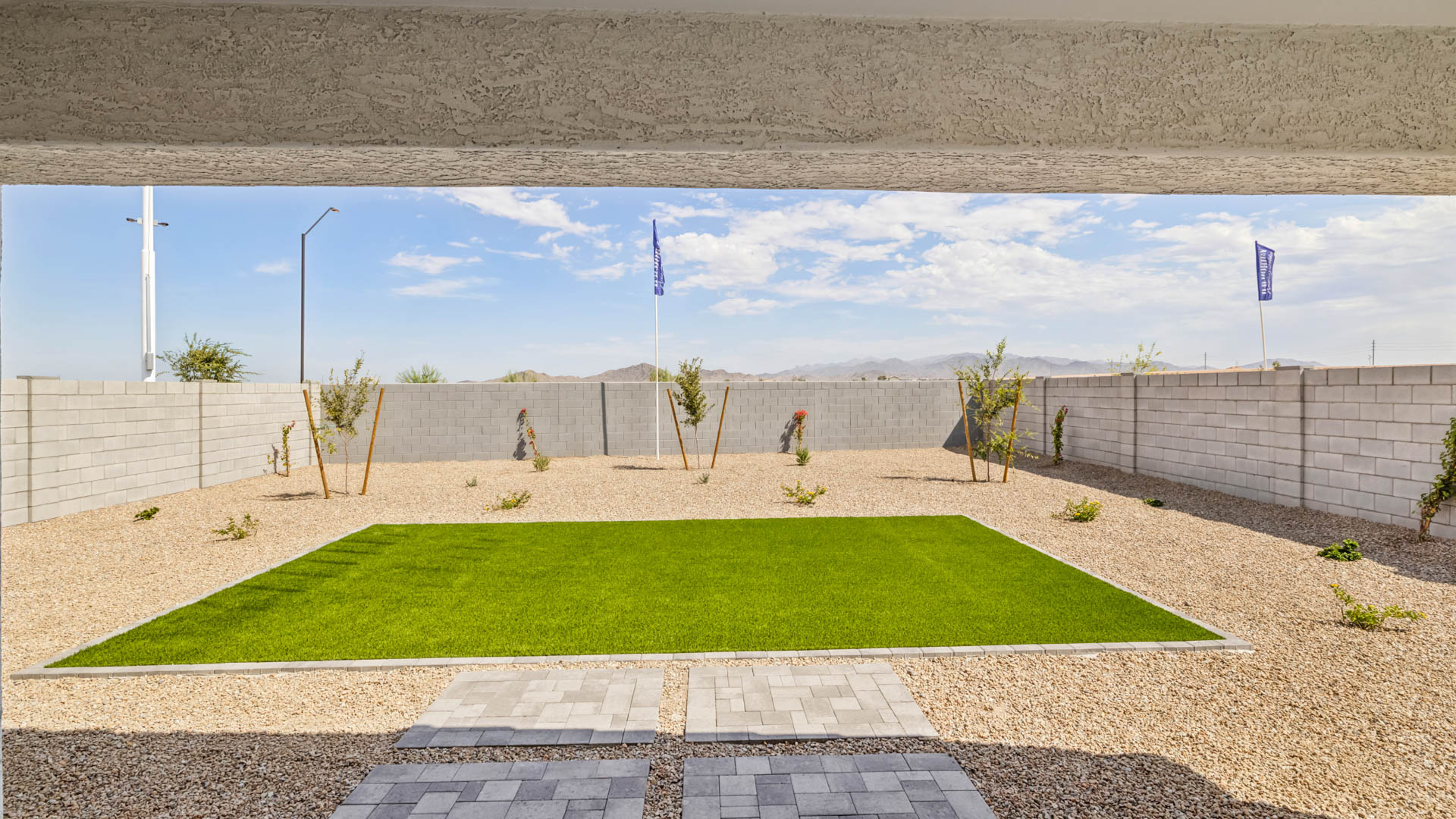 Outdoor covered patio with seating area overlooking a well-maintained lawn, perfect for relaxation.