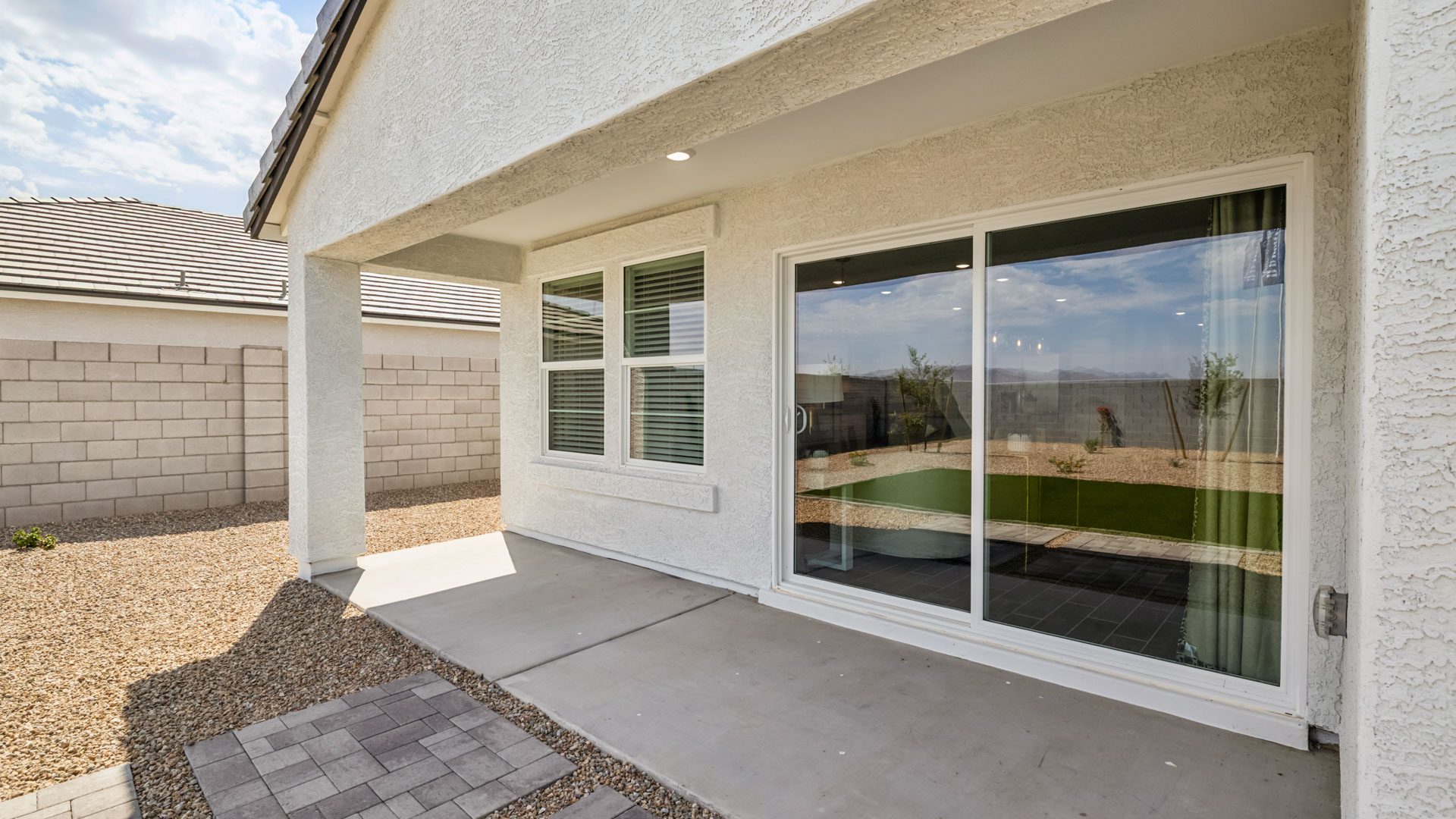 Outdoor covered patio with seating area overlooking a well-maintained lawn, perfect for relaxation.