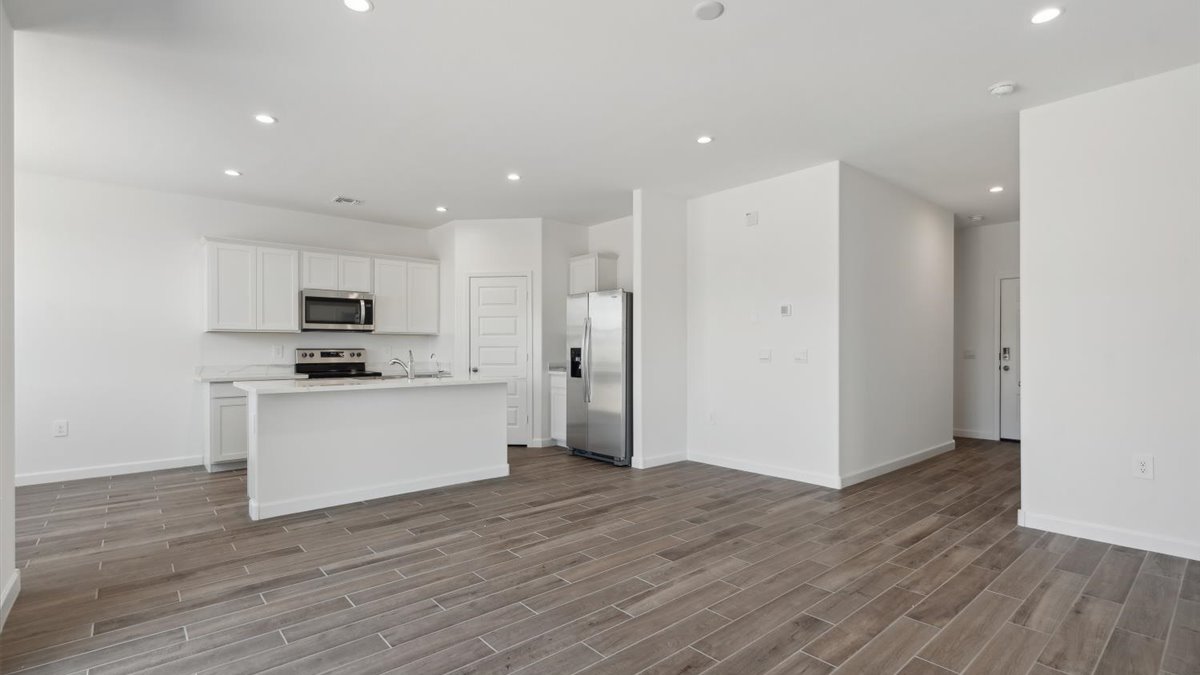 Central kitchen island with sink and seating, appliance suite included, prep zones and pantry access