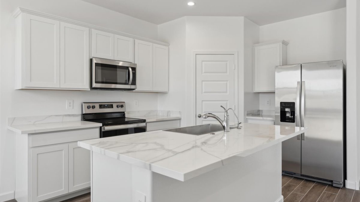 Kitchen island with sink, dining space, and prep zones designed for entertaining and everyday use