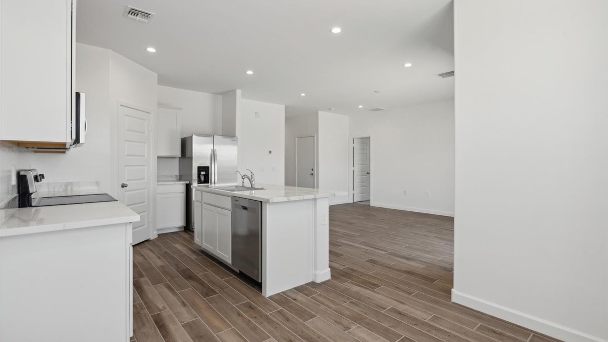 View from dining to kitchen with island, pantry, appliance suite, cabinetry and outside connectivity