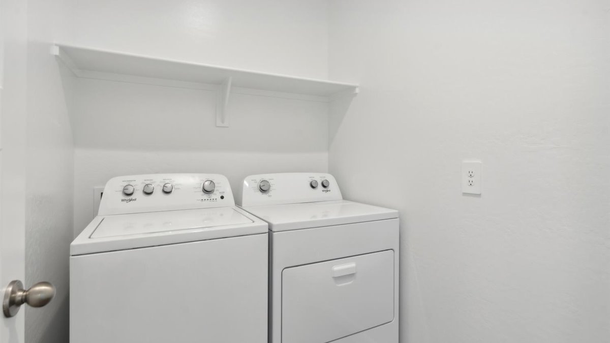 Utility laundry smartly designed with overhead storage, a drop zone, washer and dryer and hookups included