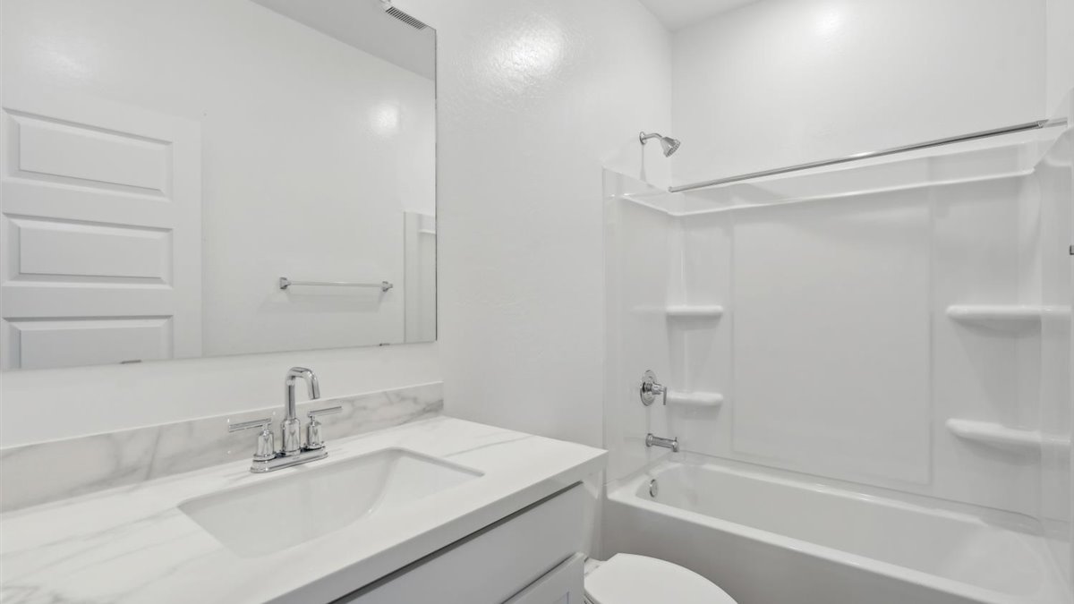 Family full bathroom 2, stylish vanity, mirror, refined fixtures, cabinets, upmarket tub-shower combo
