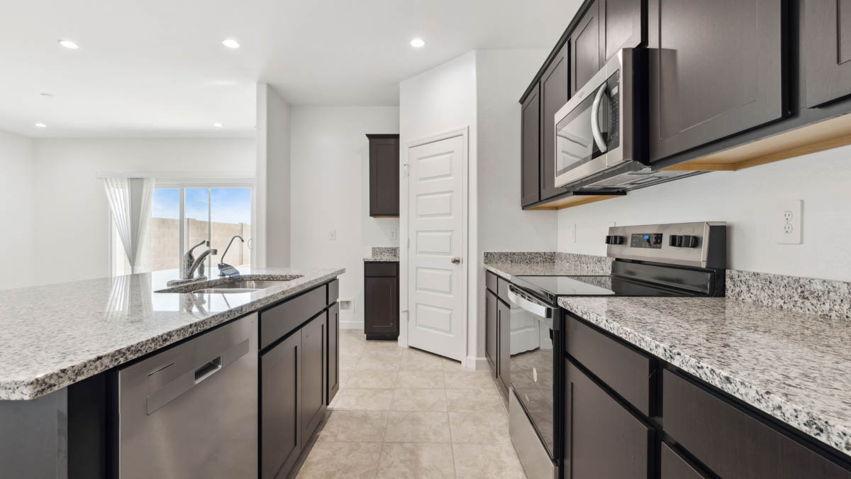 Bright and spacious kitchen with granite countertops, stainless steel appliances, and an island with bar seating.