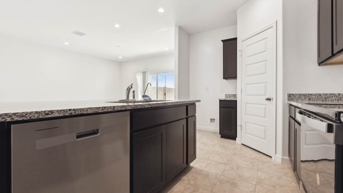 Bright and spacious kitchen with granite countertops, stainless steel appliances, and an island with bar seating.