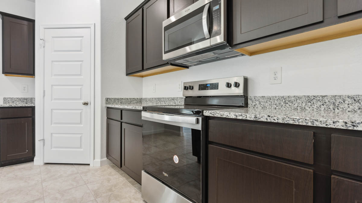 Bright and spacious kitchen with granite countertops, stainless steel appliances, and an island with bar seating.