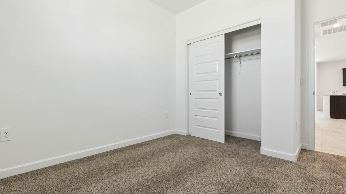 Comfortable guest bedroom featuring neutral-toned walls and a large closet.