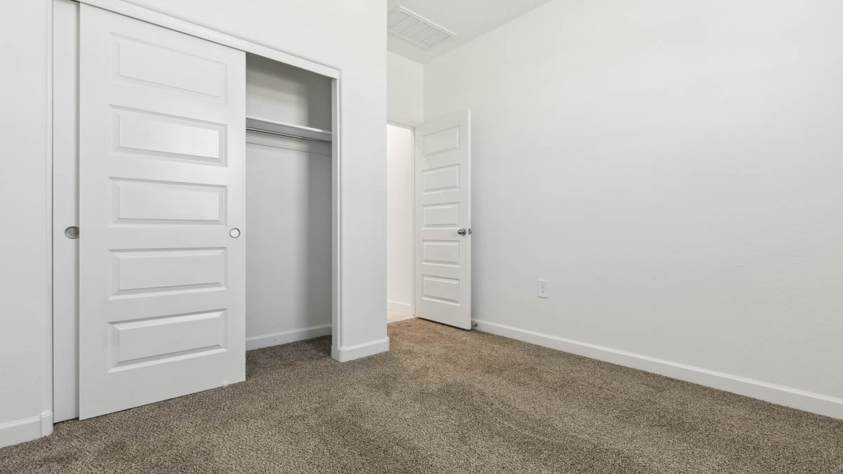 Comfortable guest bedroom featuring neutral-toned walls and a large closet.