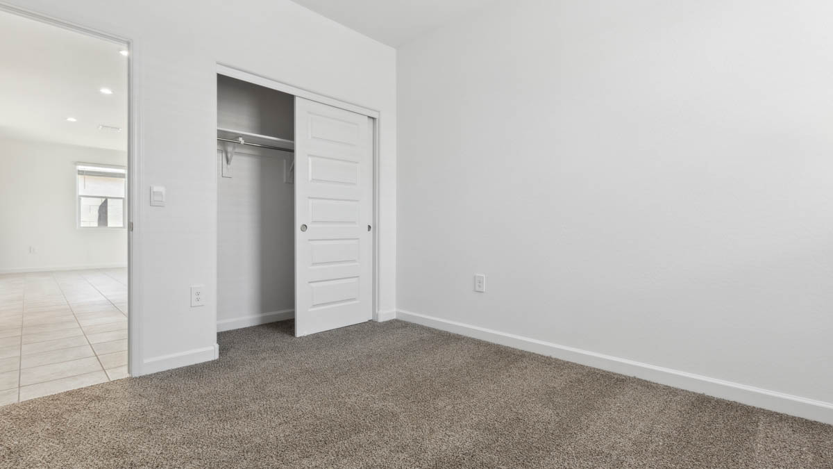 Comfortable guest bedroom featuring neutral-toned walls and a large closet.