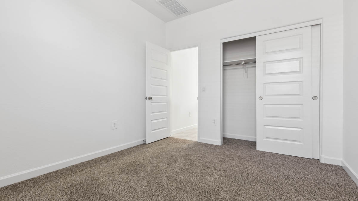 Comfortable guest bedroom featuring neutral-toned walls and a large closet.