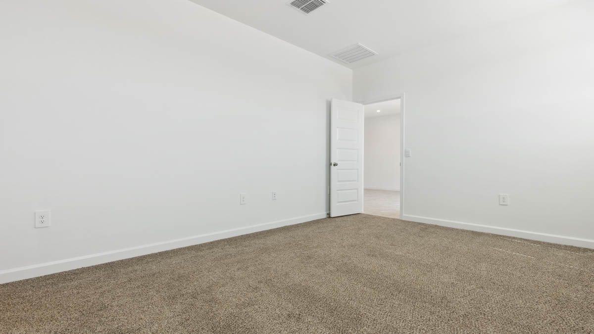 A spacious primary bedroom emphasizing open space and natural lighting.