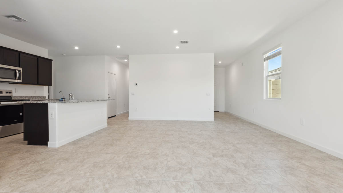 A well-organized living room that includes a kitchen and dining area, creating a warm and welcoming environment for gatherings.