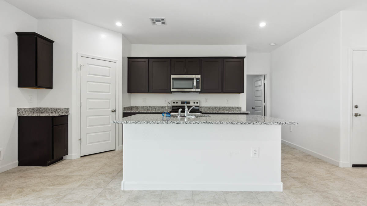 Bright and spacious kitchen with granite countertops, stainless steel appliances, and an island with bar seating.