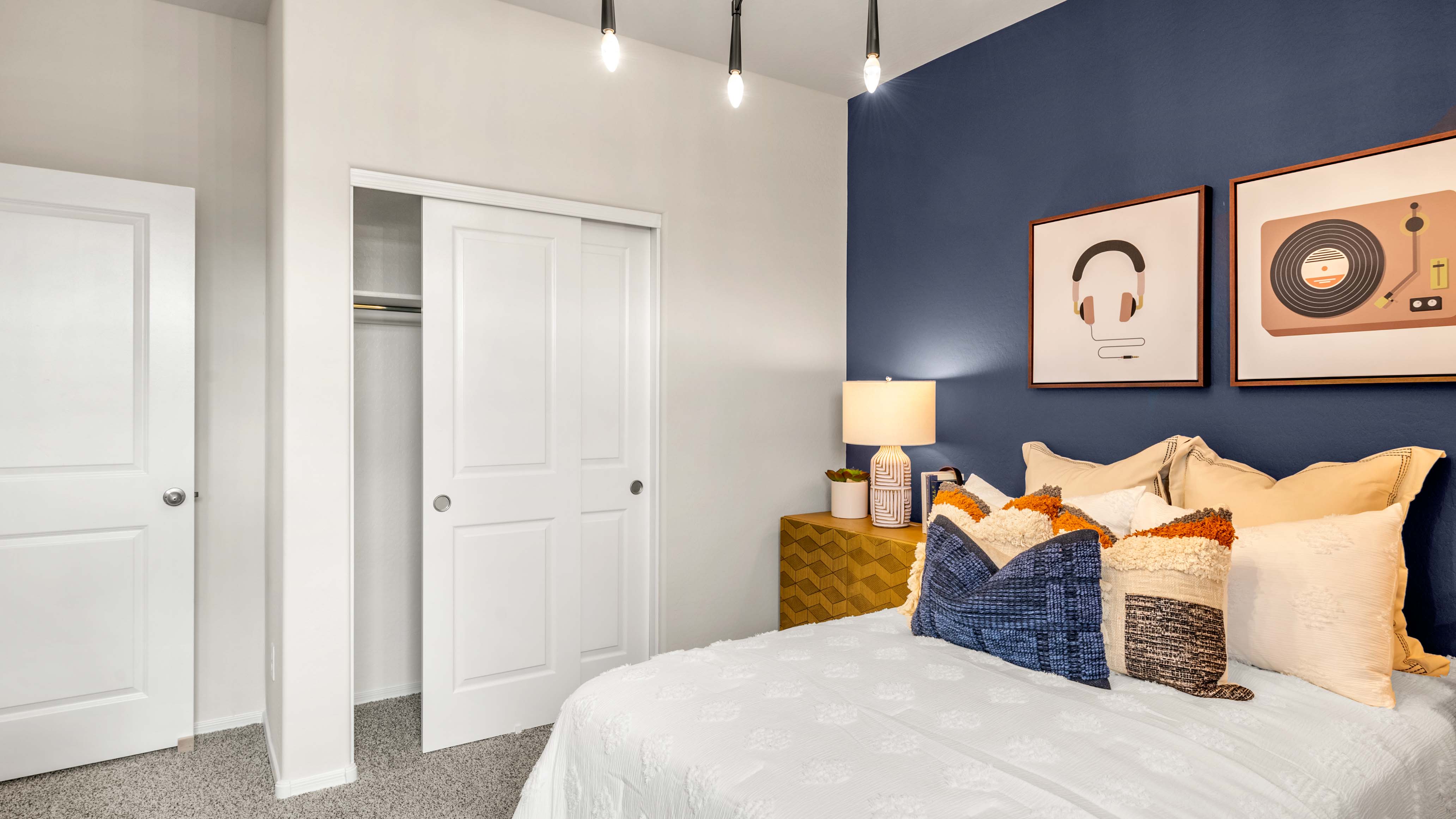 A vibrant kids' bedroom showcasing a neatly made bed, a stylish dresser, and a playful painting that adds charm.