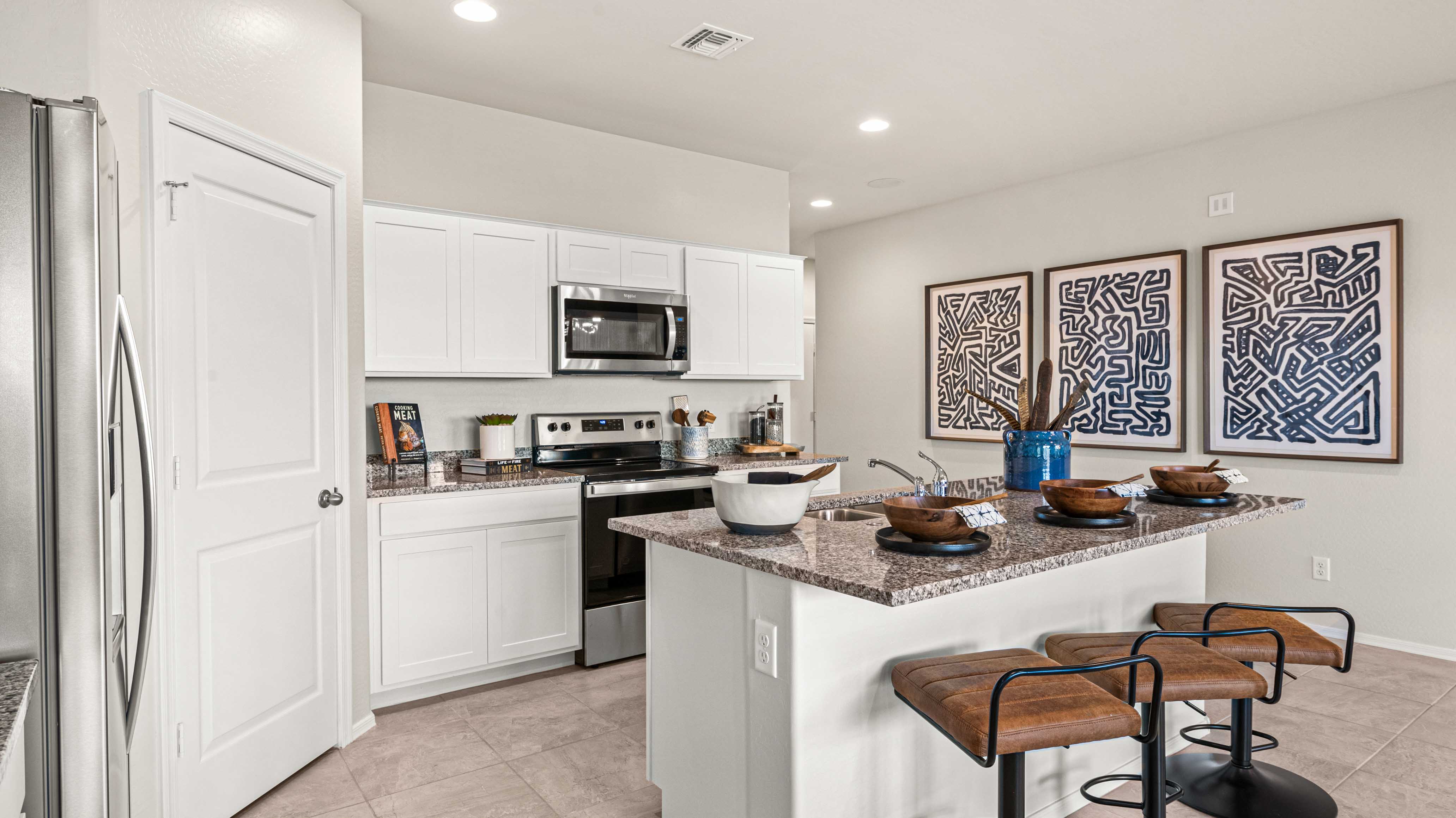 Bright and spacious kitchen with granite countertops, stainless steel appliances, and an island with bar seating.