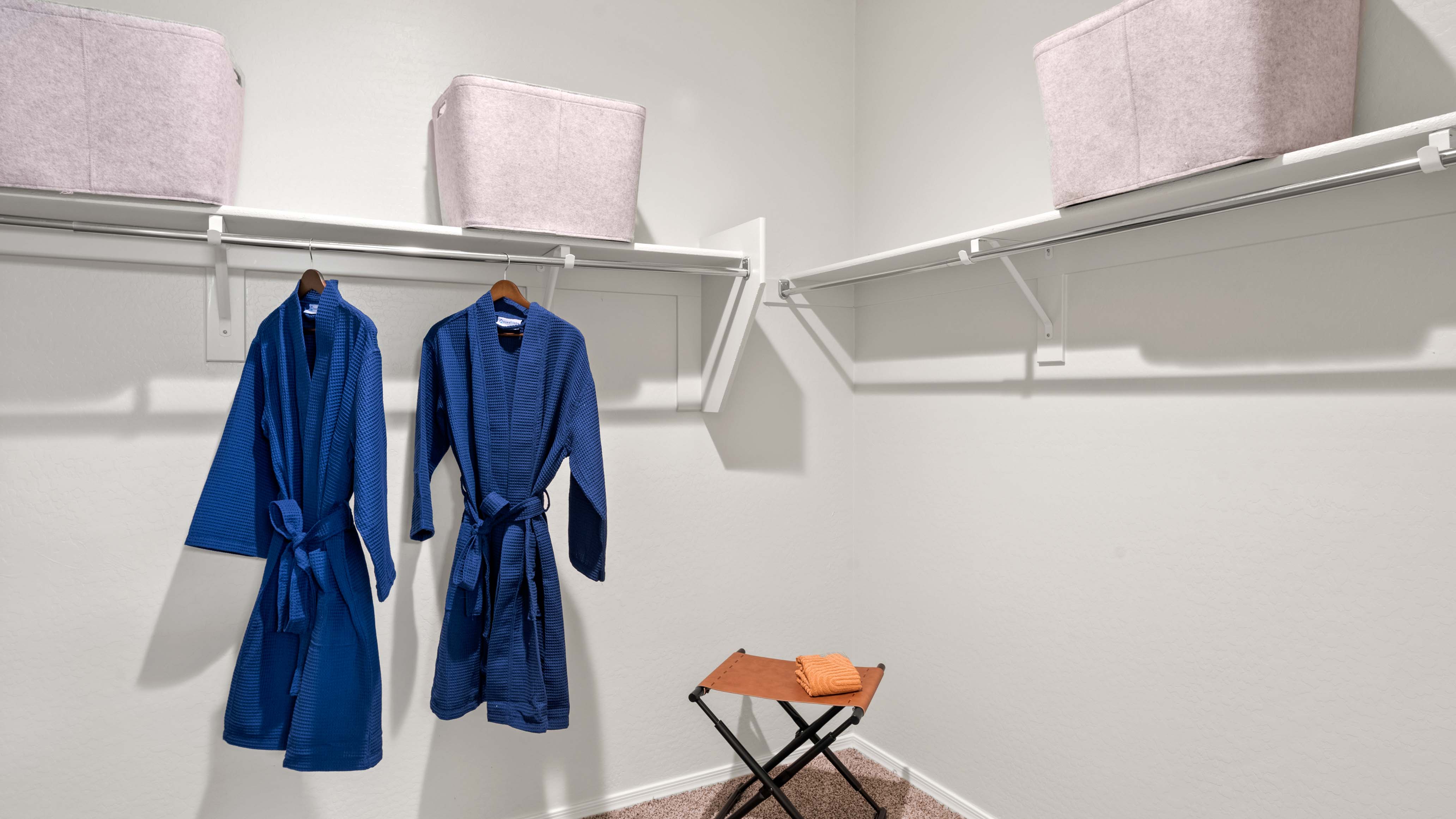 Modern primary bathroom with double vanity, granite countertops with a walk-in shower and a walk-in closet.