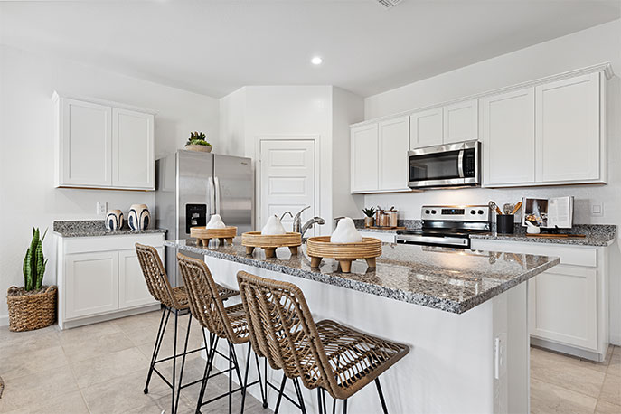 Bright and spacious kitchen with granite countertops, stainless steel appliances, and an island with bar seating.