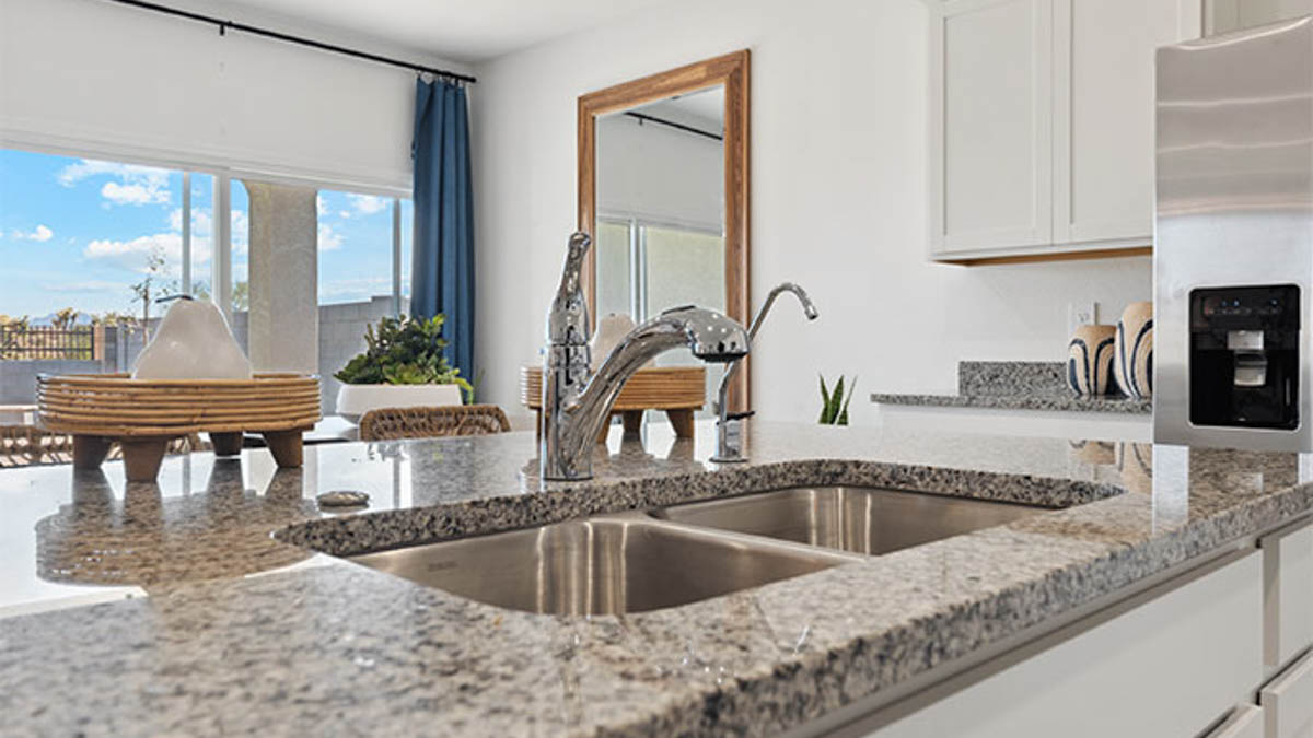 Bright and spacious kitchen with granite countertops, stainless steel appliances, and an island with bar seating.