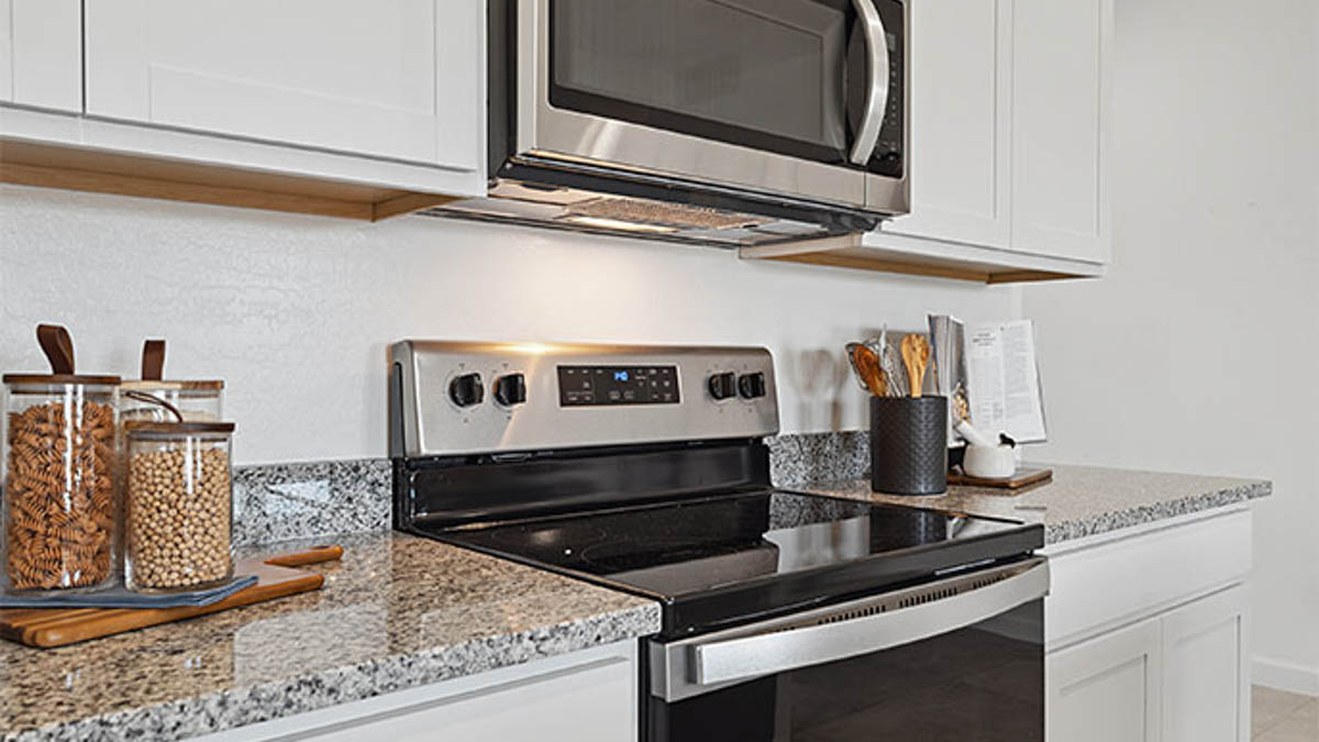 Bright and spacious kitchen with granite countertops, stainless steel appliances, and an island with bar seating.