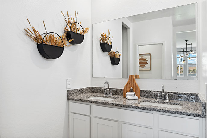 Modern primary bathroom with double vanities, with a walk-in shower and a walk-in closet.